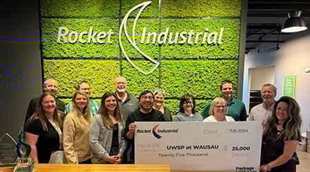 Rocket Industrial employees standing with a donation check